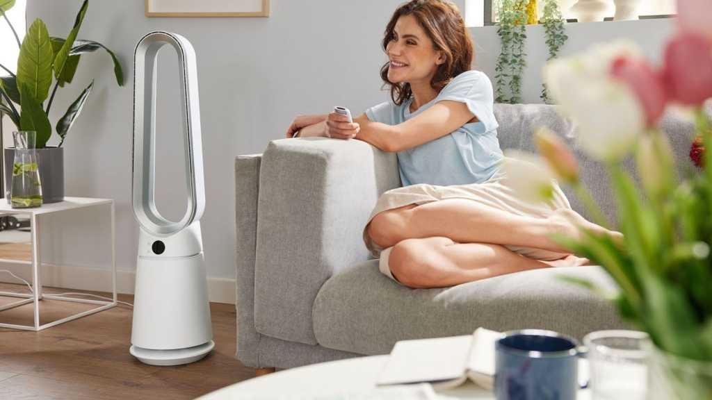 Lidl Silvercrest fan in white, next to a woman sitting on a sofa