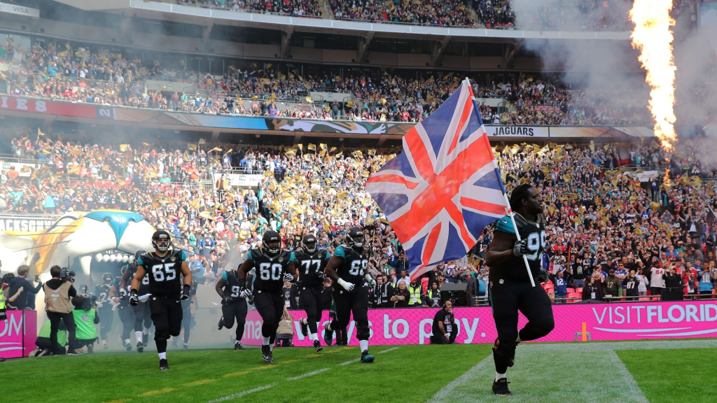 NFL players running onto a field with union jack flag