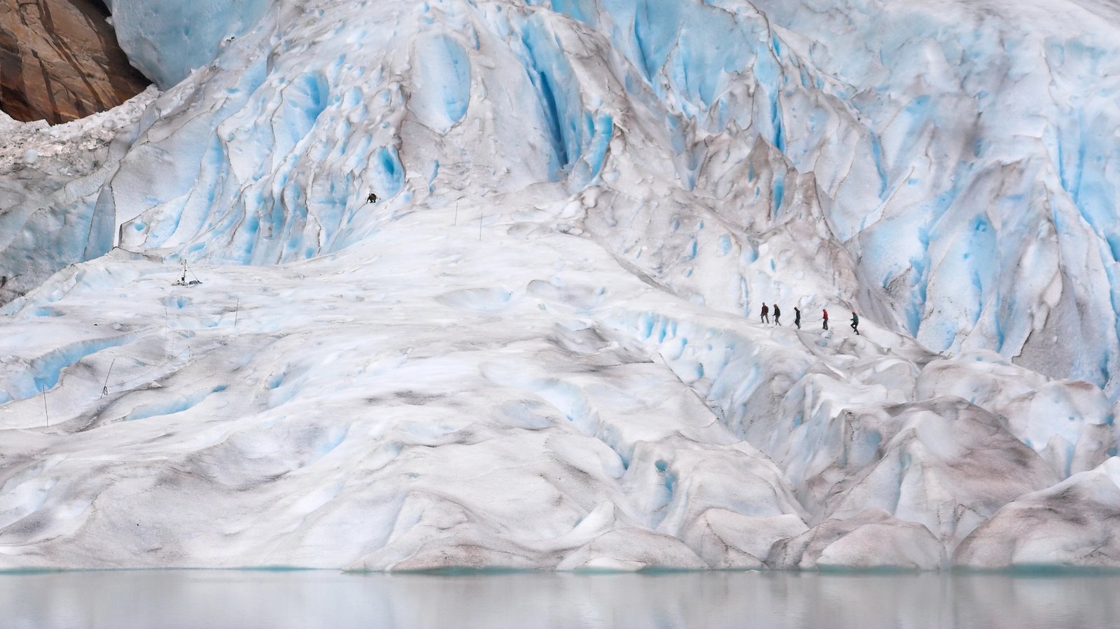 a group of people walking on a large glacier