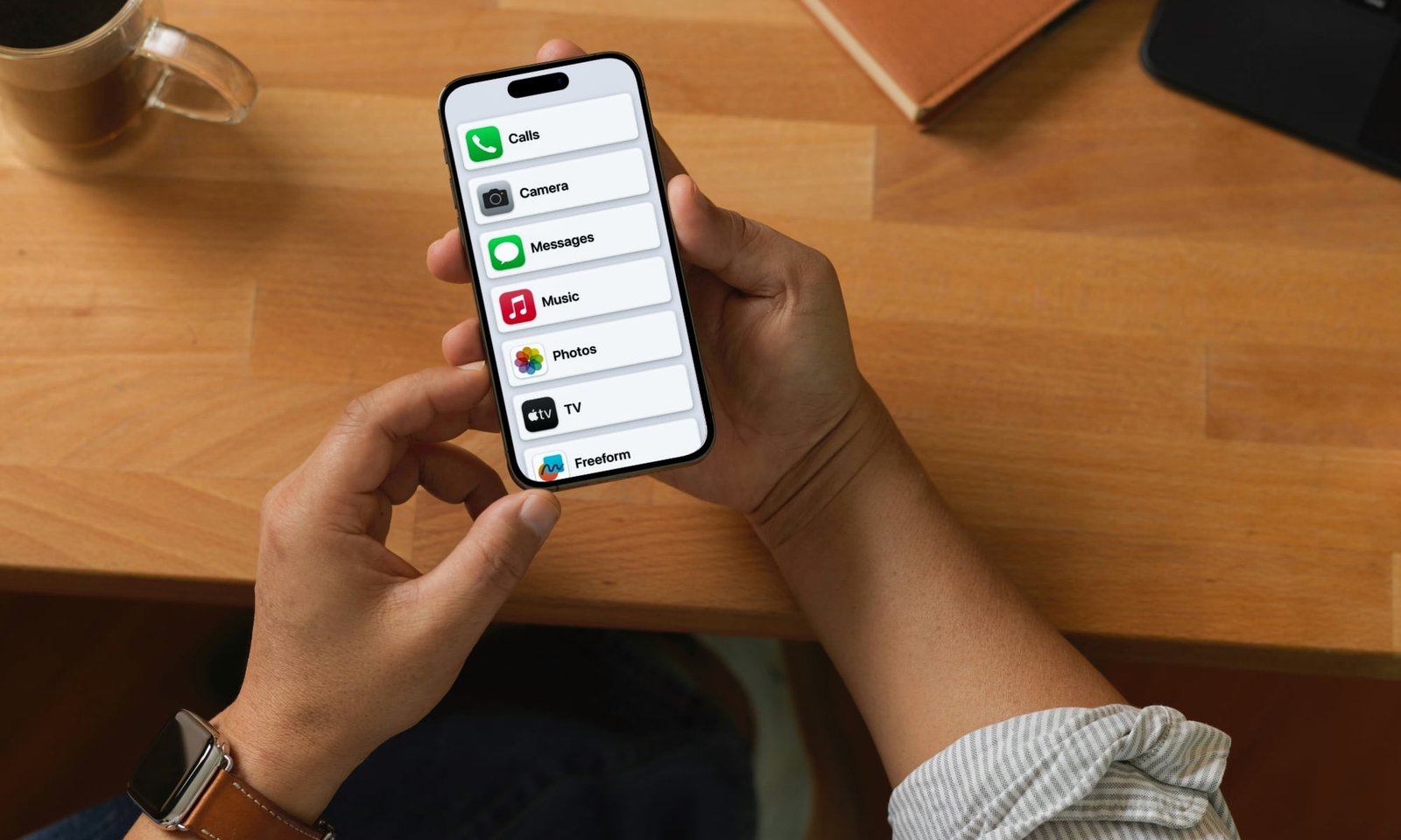 person holding iPhone with Assistive Access screen