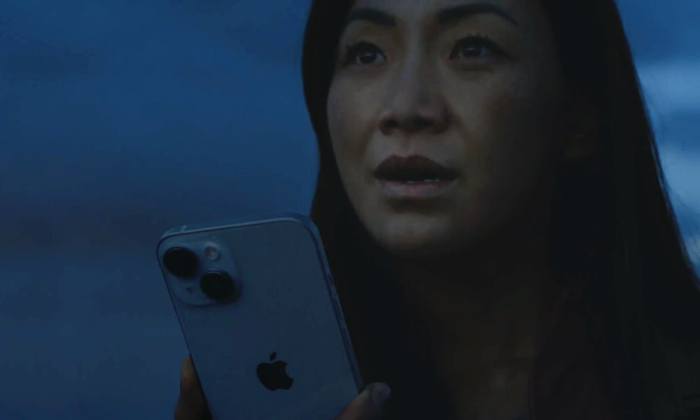 woman holding iPhone waiting for satellite rescue